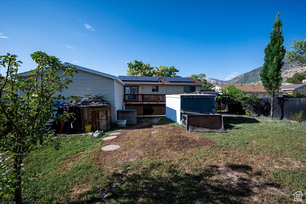 Rear view of house featuring a deck with mountain view and solar panels
