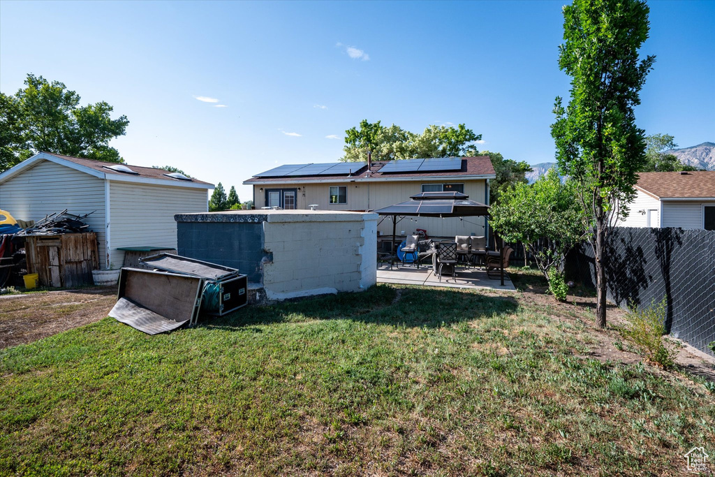 Fenced backyard with a gazebo, a patio, and a storage shed