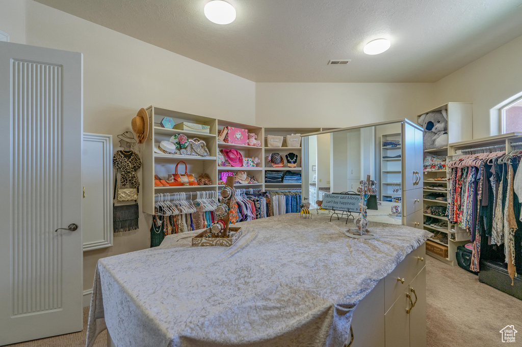 Spacious closet with light colored carpet