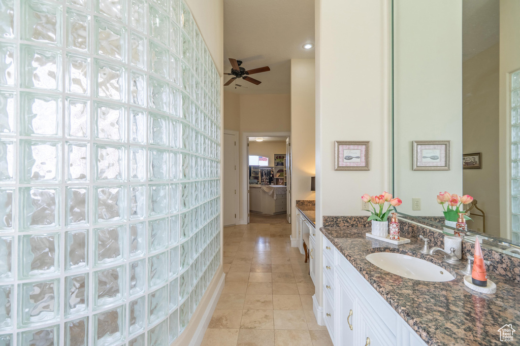 Full bathroom featuring vanity, tile patterned flooring, ceiling fan, a high ceiling, and recessed lighting