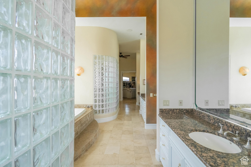 Bathroom with a garden tub, vanity, and tile patterned flooring