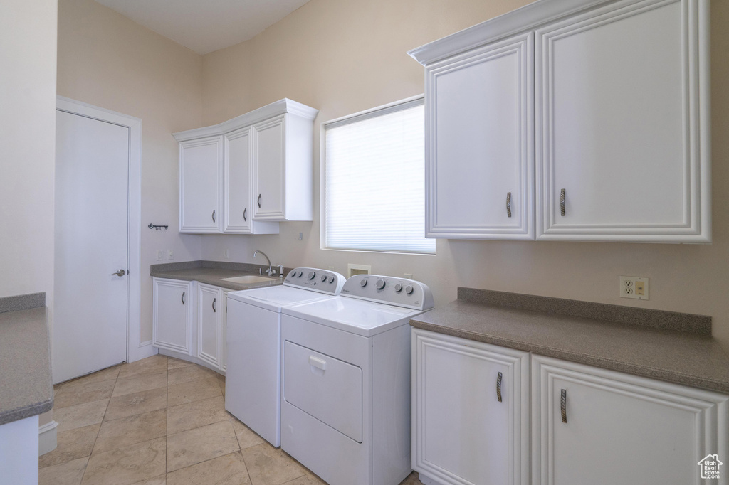 Washroom featuring washer and clothes dryer and cabinet space
