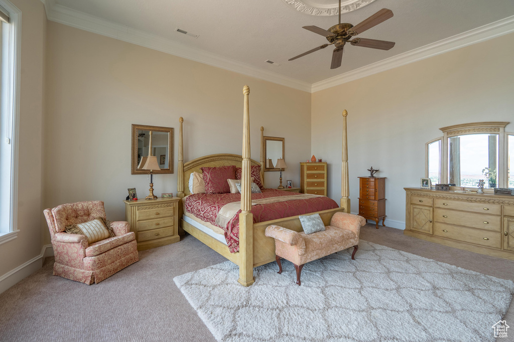 Bedroom featuring light colored carpet, ornamental molding, and a ceiling fan