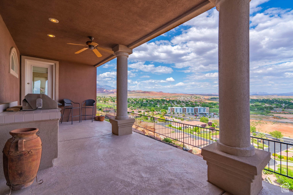 Patio / terrace with a ceiling fan and a mountain view