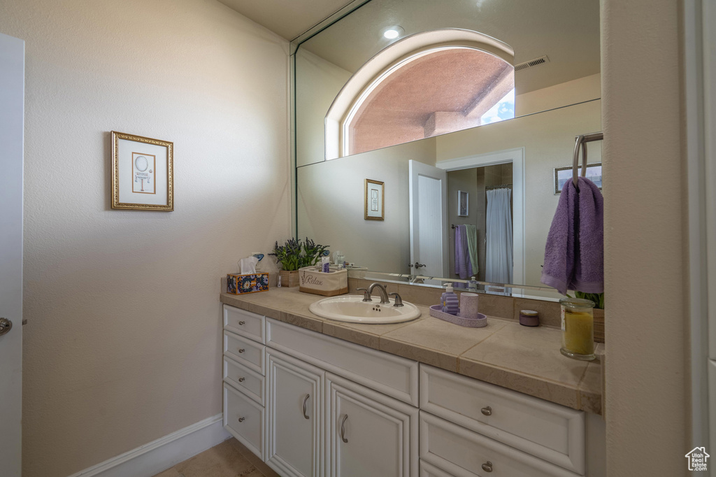 Full bath featuring vanity and baseboards