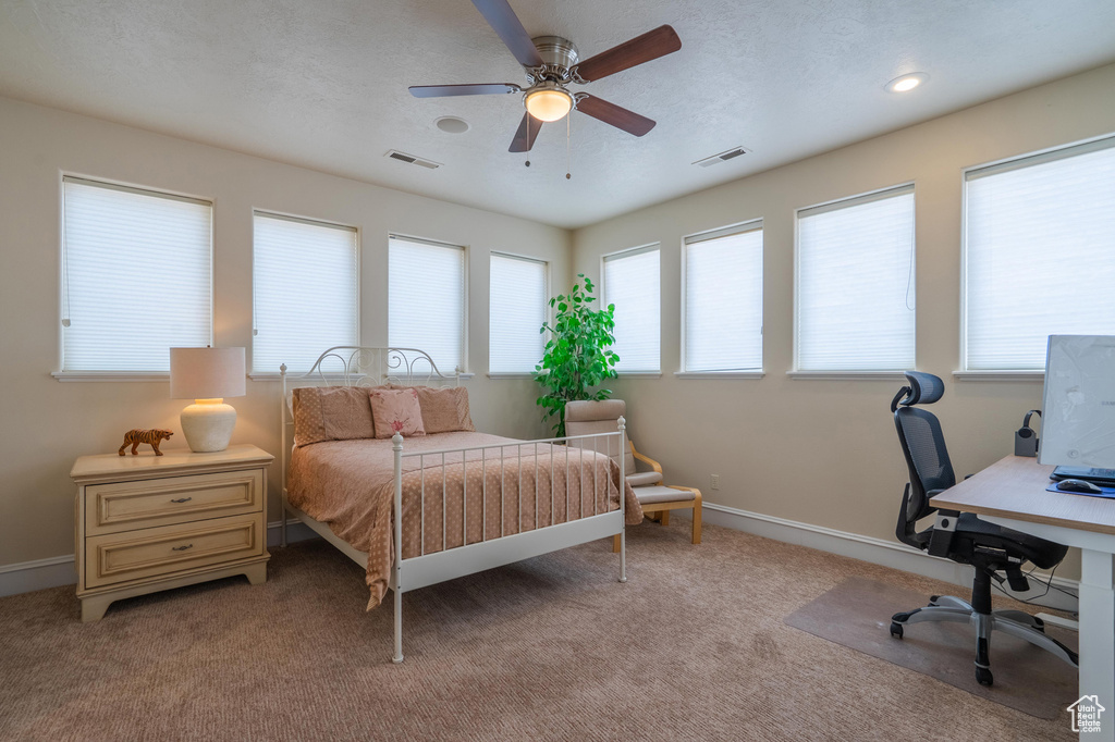 Bedroom featuring light carpet, a desk, and ceiling fan