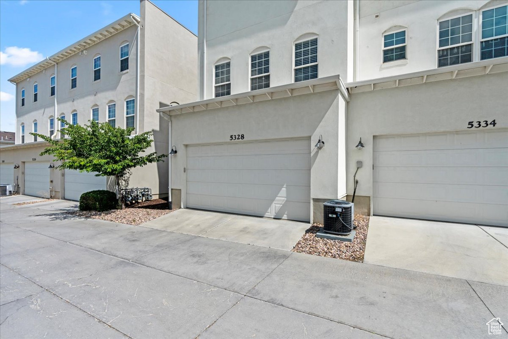 Townhome / multi-family property with stucco siding, a garage, and driveway