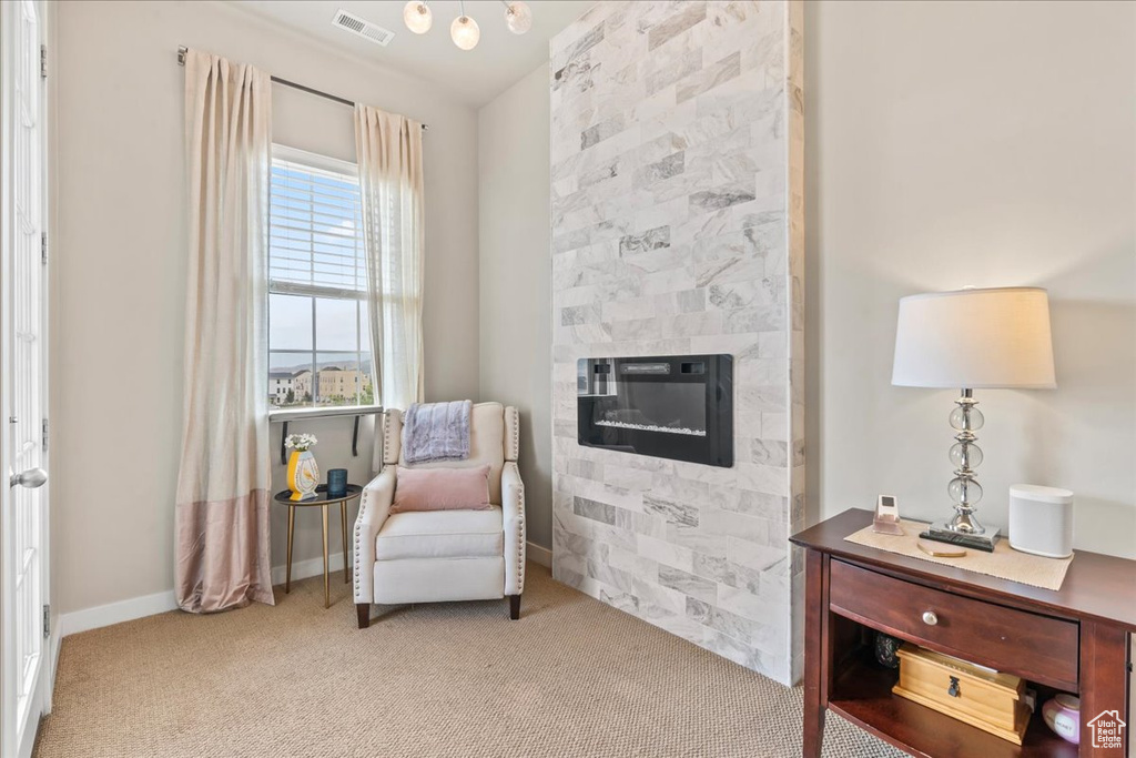 Living area with carpet floors and a large fireplace