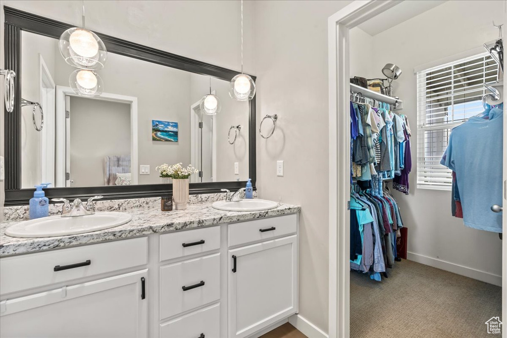 Bathroom featuring double vanity and a spacious closet