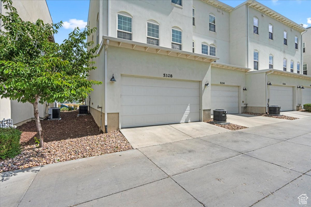 Townhome / multi-family property with stucco siding, a garage, and concrete driveway