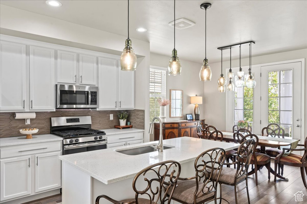 Kitchen with stainless steel appliances, plenty of natural light, a breakfast bar, backsplash, and recessed lighting