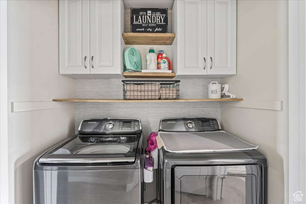 Laundry area with separate washer and dryer and cabinet space