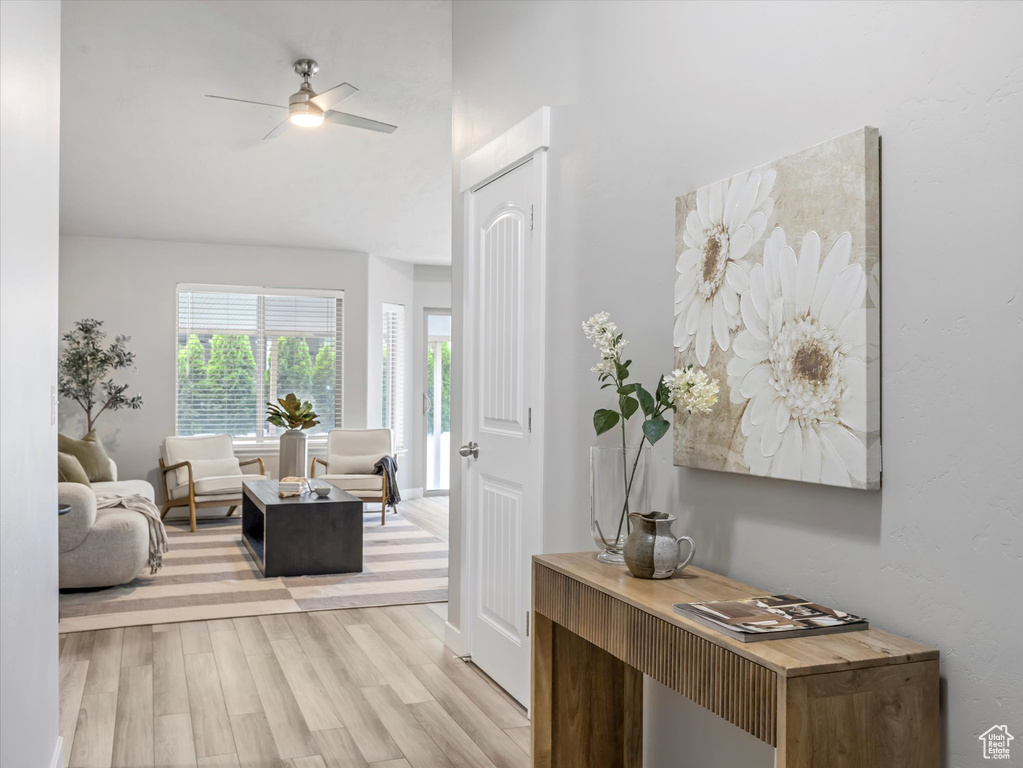 Living area with light wood-style flooring and a ceiling fan