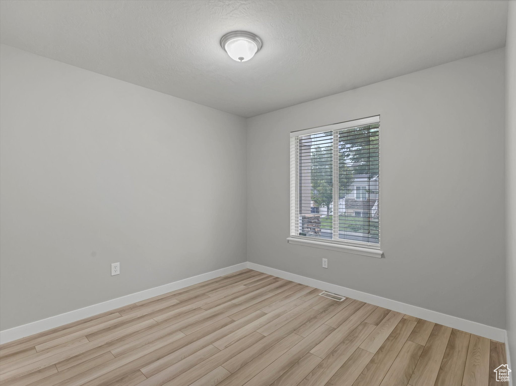 Empty room with light wood-style floors and baseboards