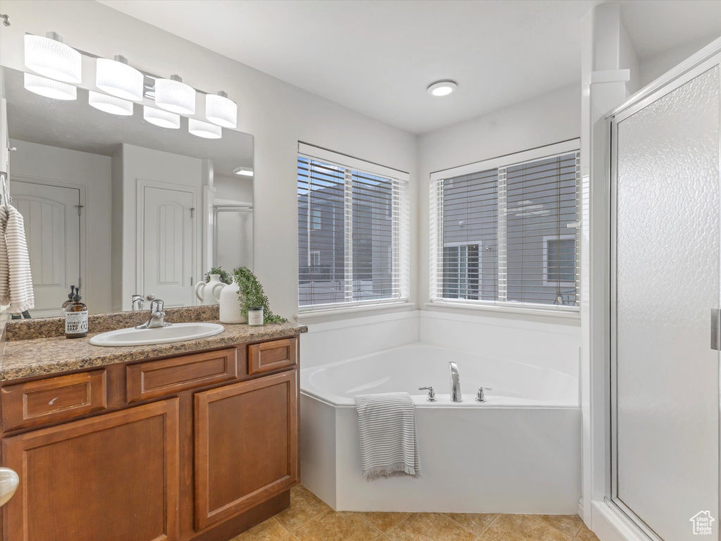Bathroom with vanity, a garden tub, a shower stall, and tile patterned floors