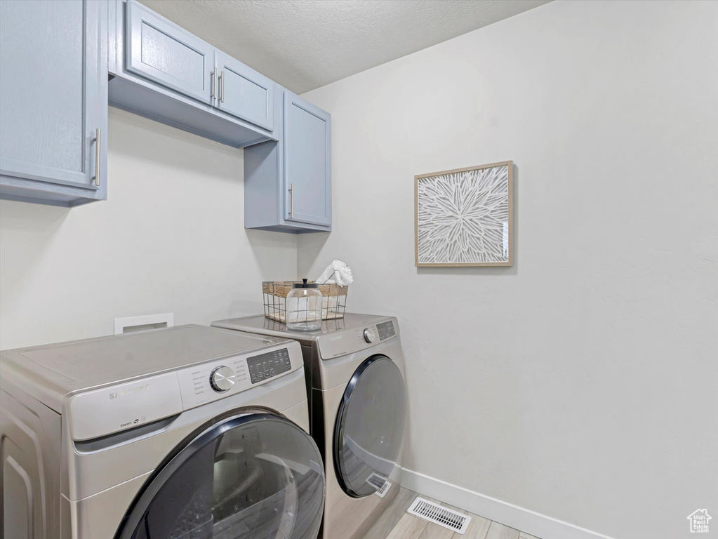 Laundry area with cabinet space and washing machine and clothes dryer