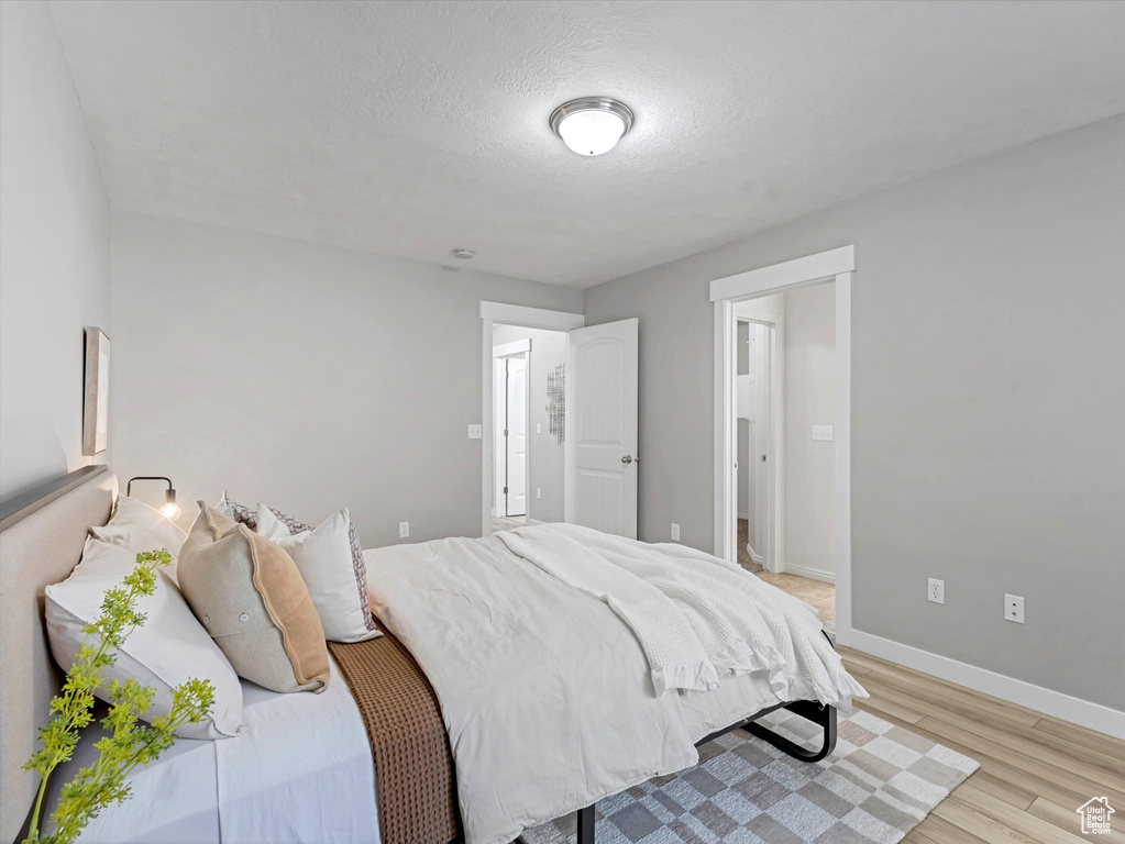 Bedroom featuring light wood-style floors and a textured ceiling