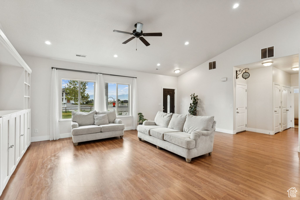 Living room featuring a ceiling fan, recessed lighting, light wood finished floors, and lofted ceiling