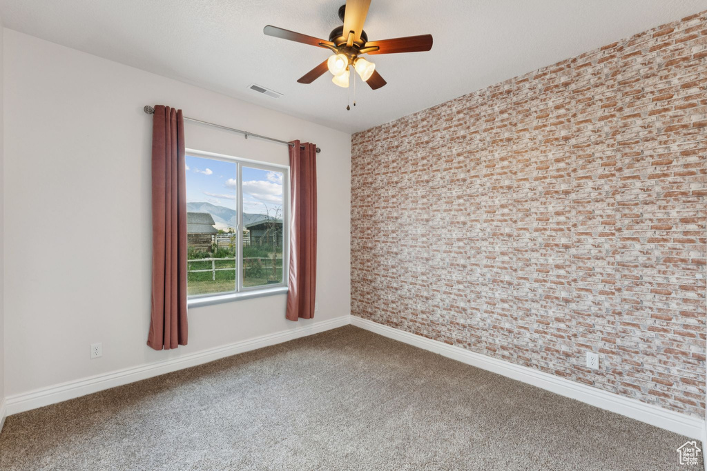 Empty room with carpet and a ceiling fan