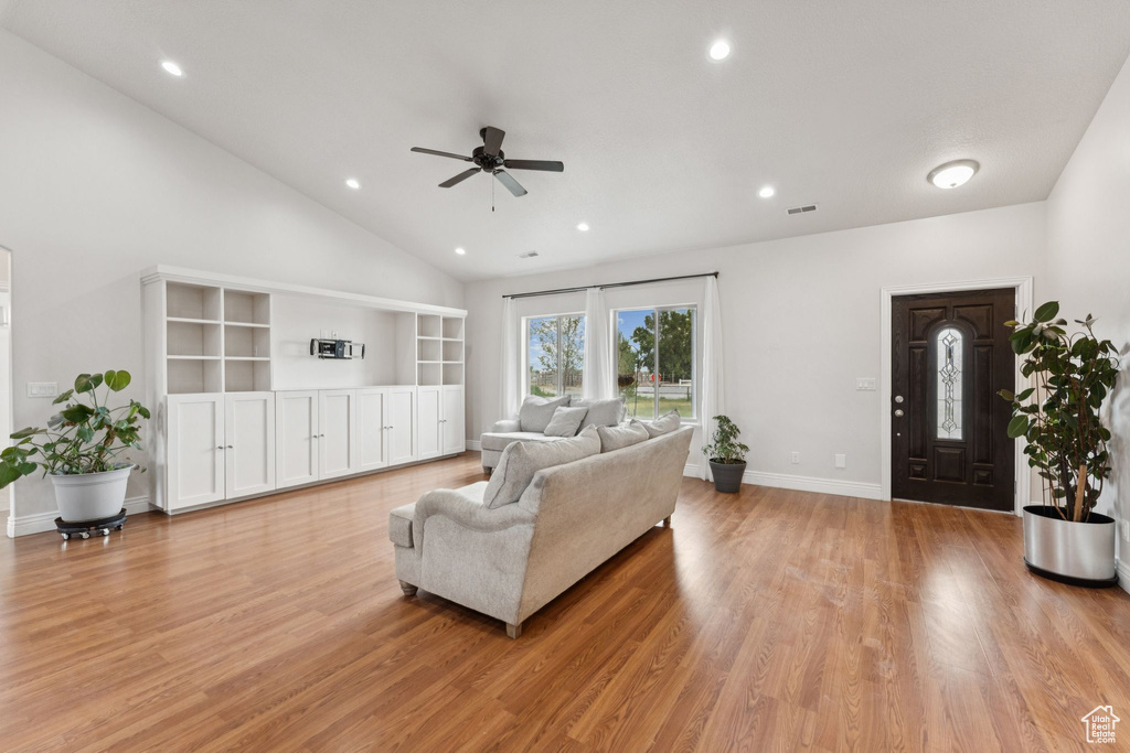 Living area with ceiling fan, light wood-type flooring, recessed lighting, and high vaulted ceiling