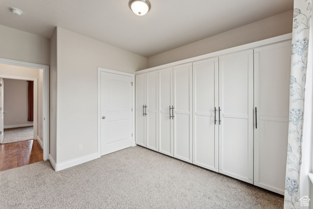 Unfurnished bedroom featuring carpet and a closet