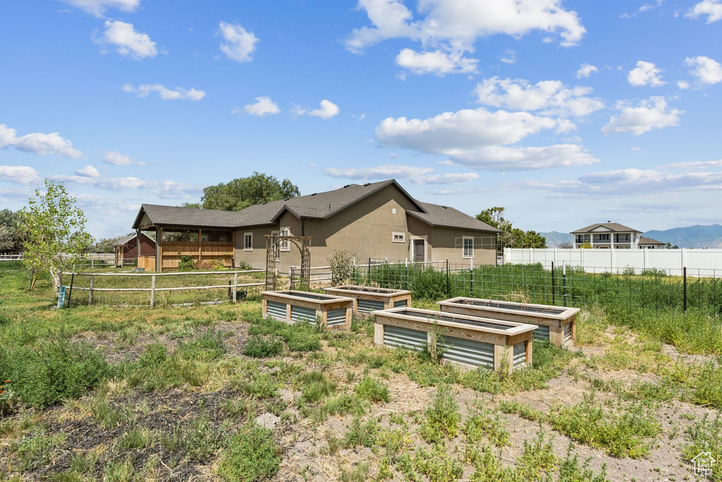 Back of house featuring a garden and stucco siding