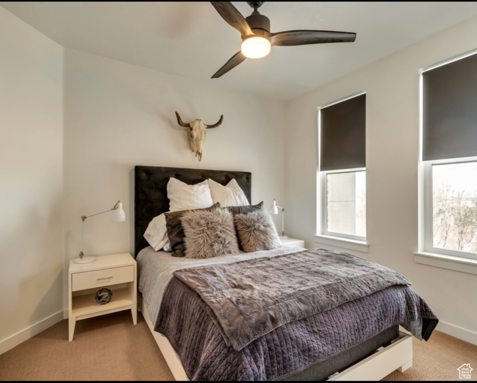 Carpeted bedroom with baseboards and a ceiling fan