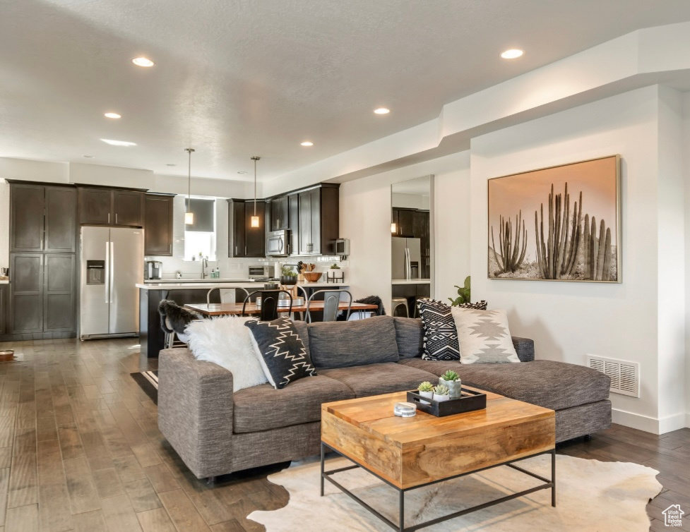 Living area with hardwood / wood-style flooring and recessed lighting