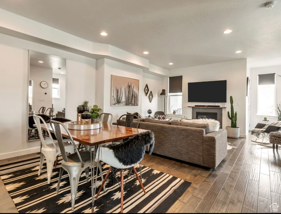 Dining space with dark wood-style flooring, recessed lighting, and a fireplace