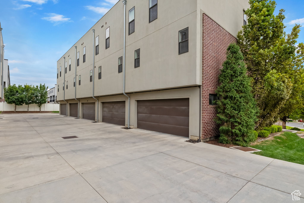 View of building exterior with driveway and a garage