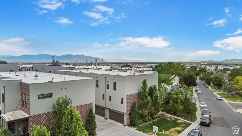 View of building exterior with a mountain view, a garage, and concrete driveway