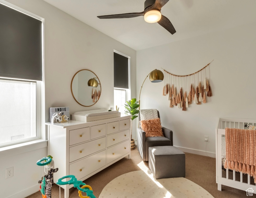 Carpeted bedroom featuring baseboards and a ceiling fan