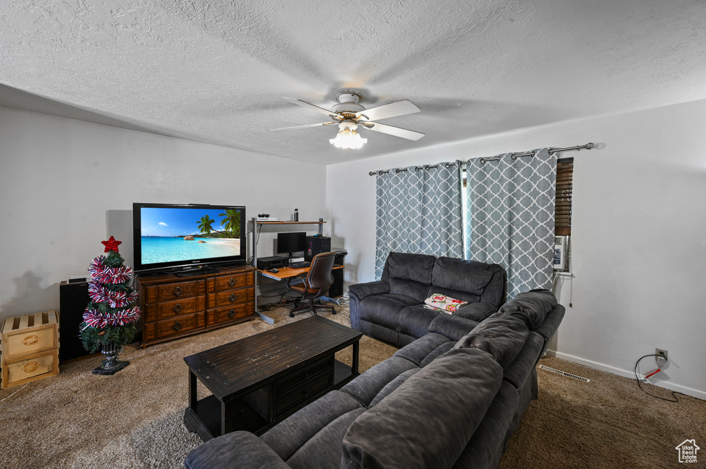 Living area with carpet flooring, a textured ceiling, a ceiling fan, and an office area