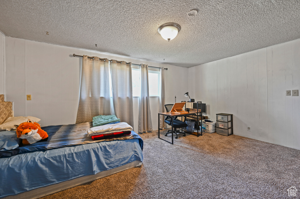 Bedroom featuring carpet flooring and a textured ceiling