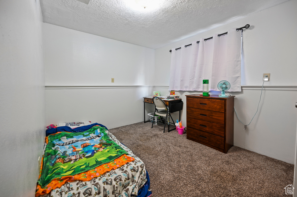 Bedroom featuring carpet floors and a textured ceiling