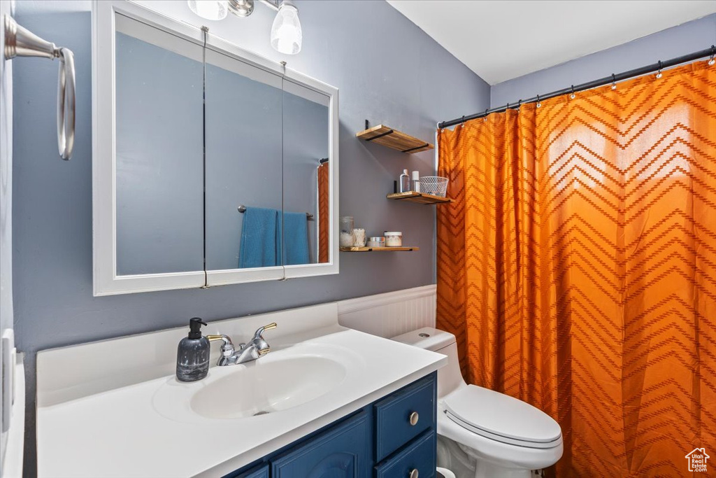 Bathroom featuring vanity, wainscoting, and a shower with curtain