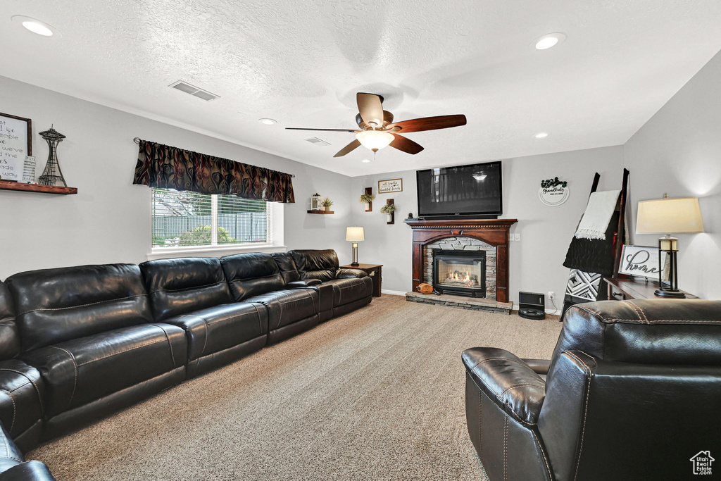 Living area with ceiling fan, a fireplace, carpet, recessed lighting, and a textured ceiling
