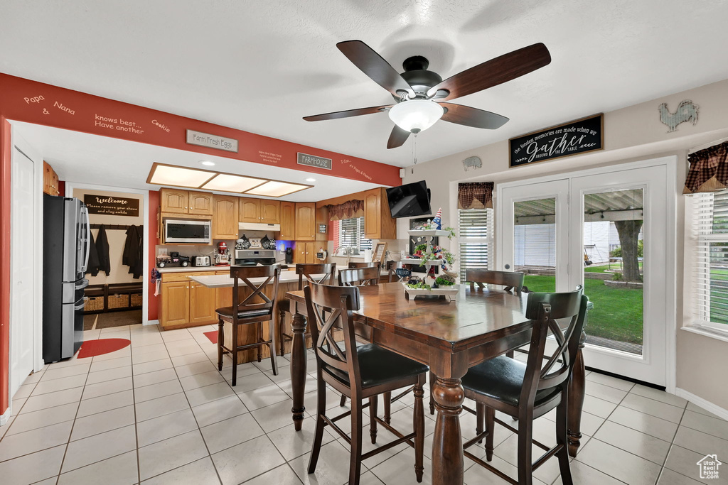 Dining area featuring a ceiling fan and light tile patterned floors