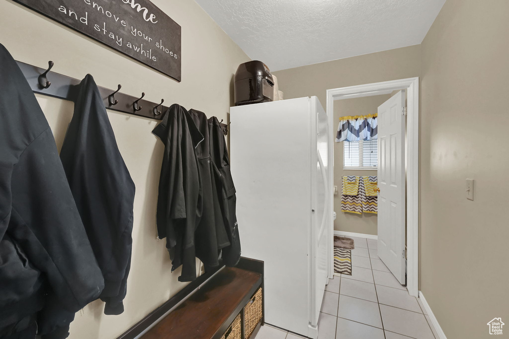 Mudroom with light tile patterned floors and a textured ceiling