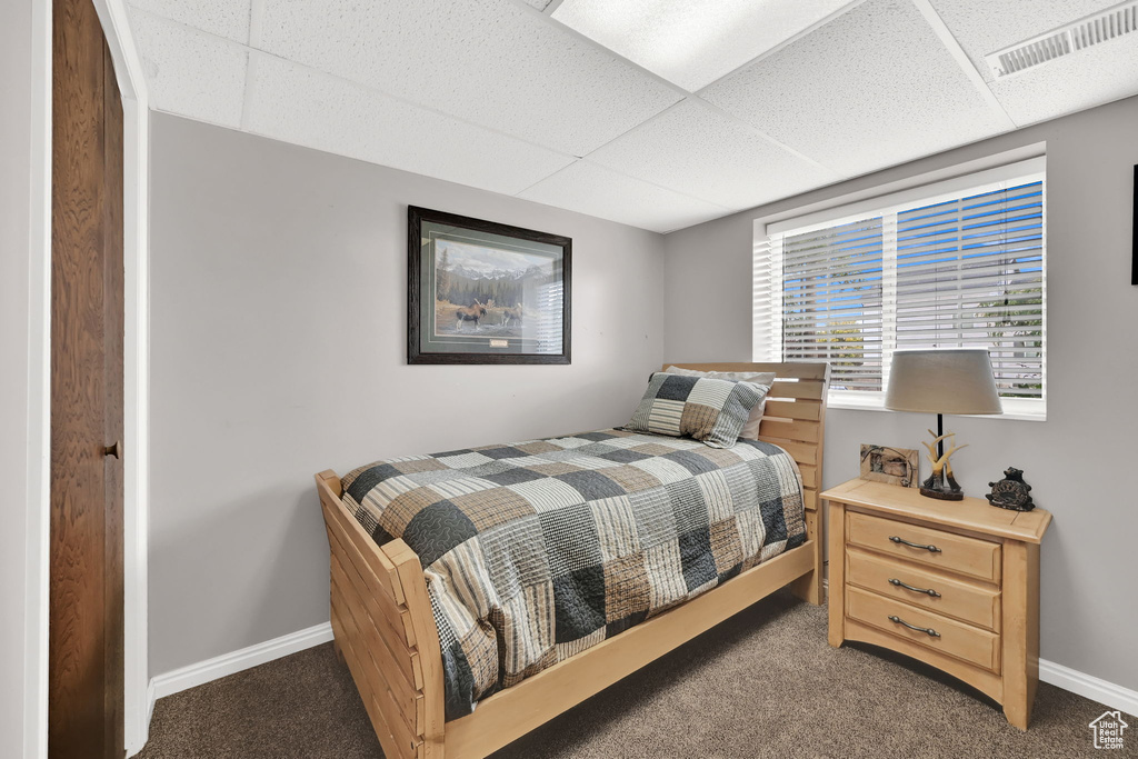 Bedroom with carpet floors and a drop ceiling