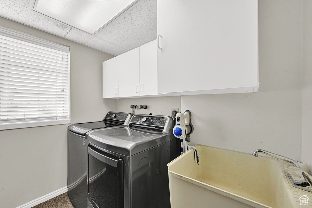 Washroom with washer and clothes dryer and cabinet space