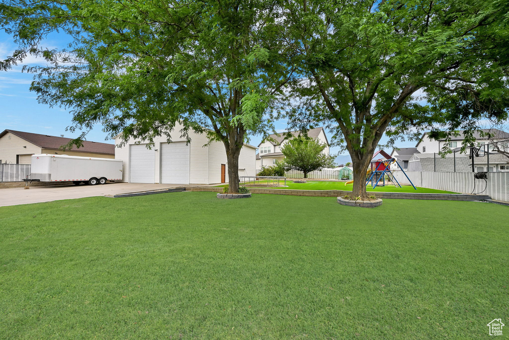 View of yard with a playground and a garage