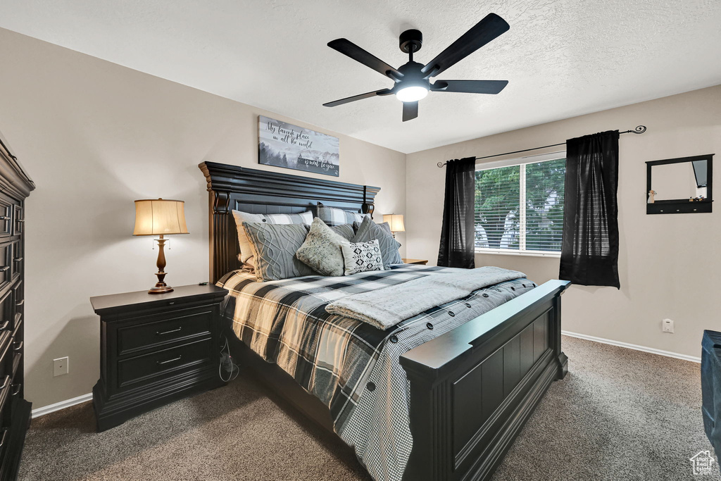Bedroom featuring dark colored carpet and a ceiling fan