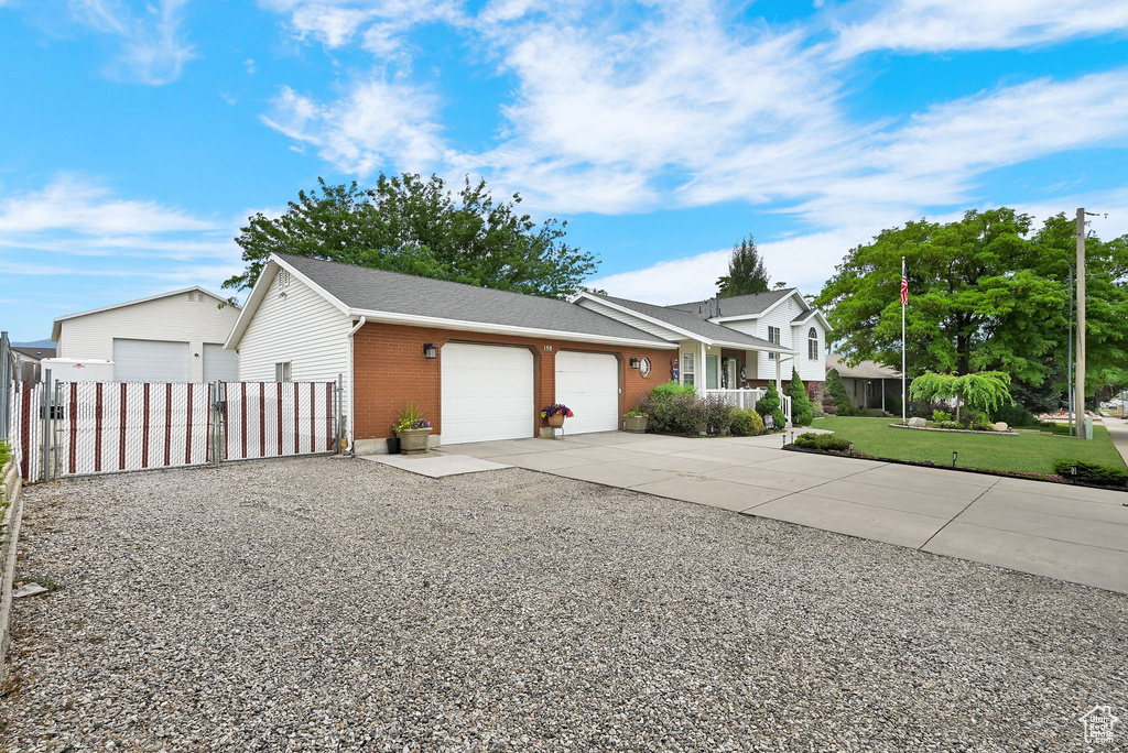 View of front of house featuring an attached garage, brick siding, concrete driveway, and a shingled roof