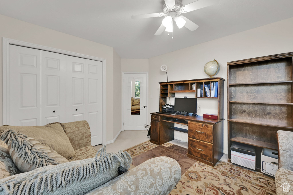 Office with light colored carpet and a ceiling fan