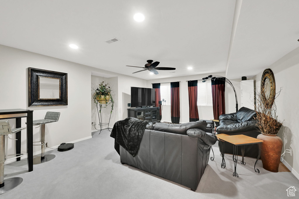 Carpeted living area featuring a ceiling fan and recessed lighting