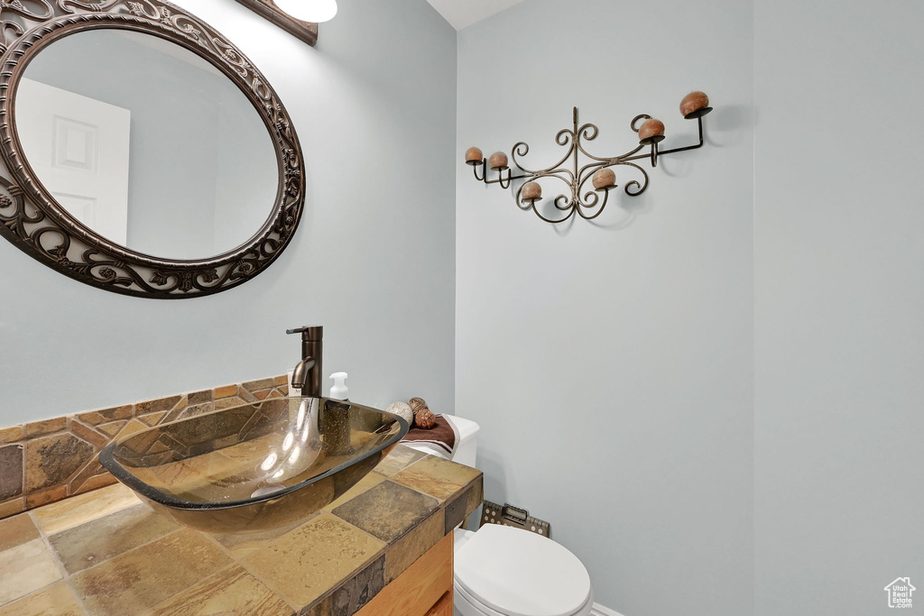 Half bathroom with stone finish floors and vanity