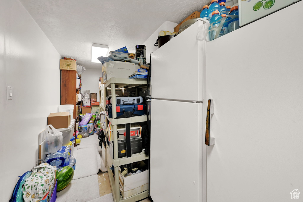 Kitchen with freestanding refrigerator and a textured ceiling