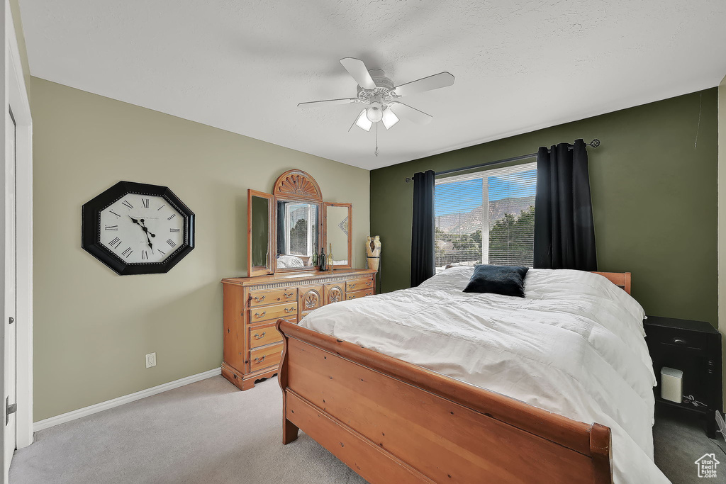 Bedroom with light colored carpet and a ceiling fan