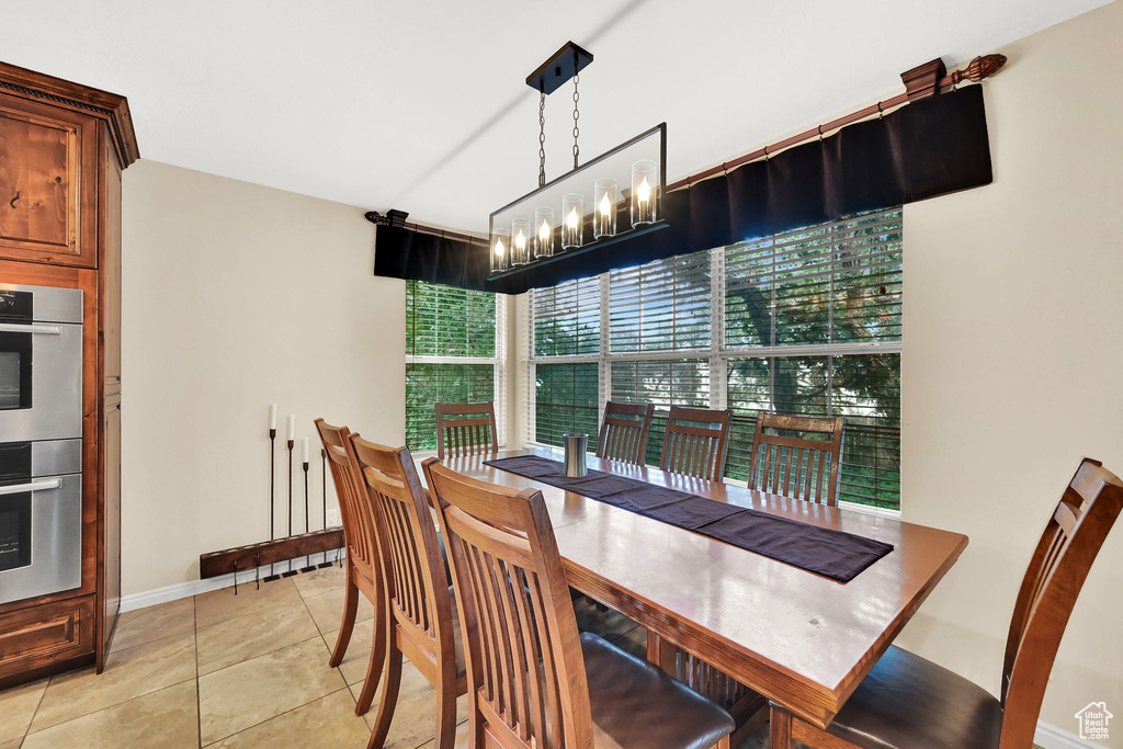Dining space with light tile patterned floors and a chandelier
